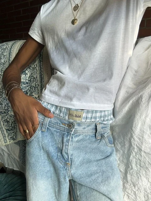 A mannequin wearing a white shirt and blue jeans.