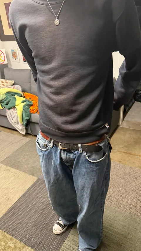 A mannequin wearing a black shirt and jeans.
