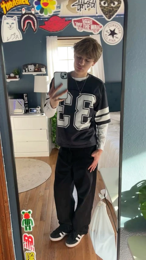 A young man taking a picture of himself in a mirror.