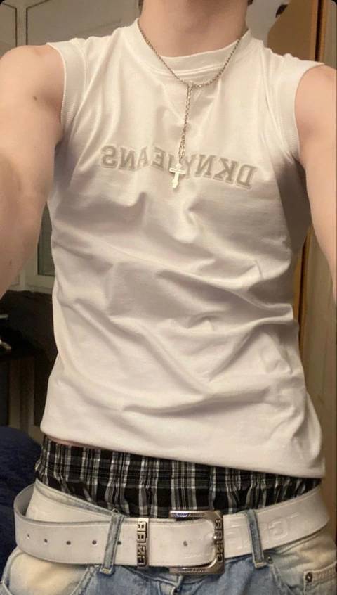 A mannequin wearing a white tank top with a cross on it.