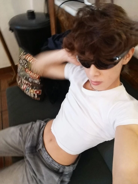 A woman wearing sunglasses and a white shirt.