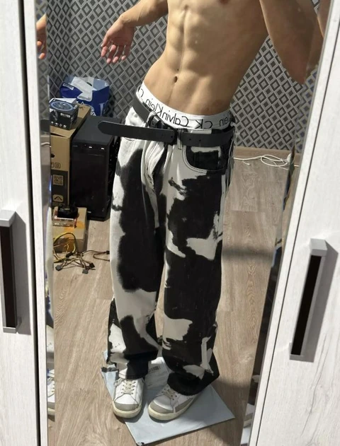 A man standing in front of a mirror with his hands on his hips.