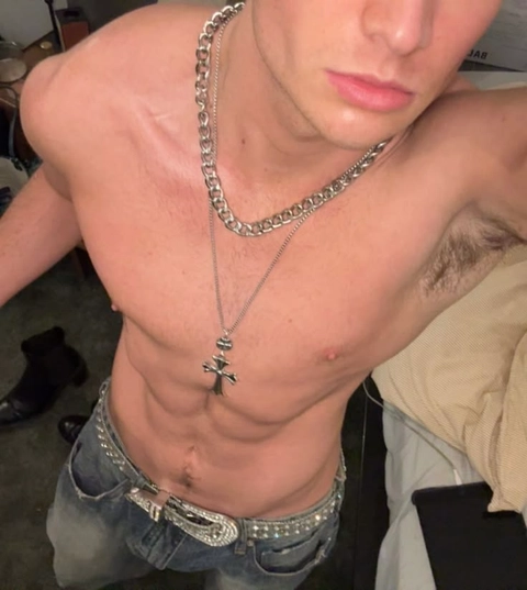 A shirtless man with a cross on his chest.