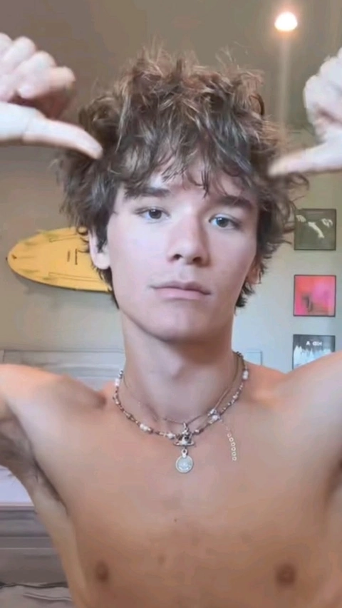 A shirtless man with a necklace on his neck.