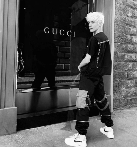 A man standing in front of a gucci store.