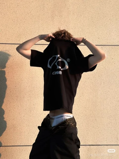 a man standing on top of a wall with his hands on his head