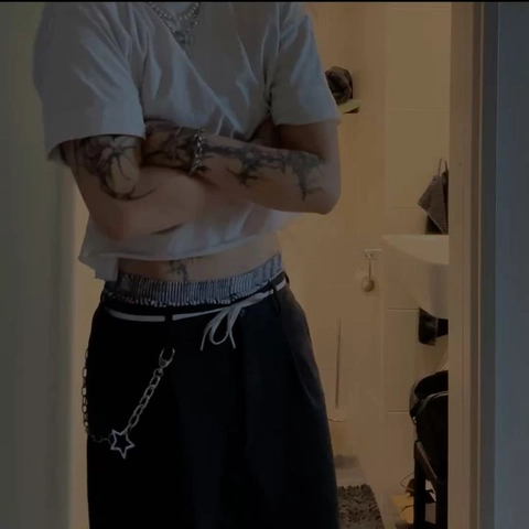 A woman with tattoos standing in front of a mirror.
