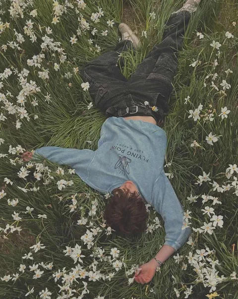 A woman laying on top of a bed of white flowers.