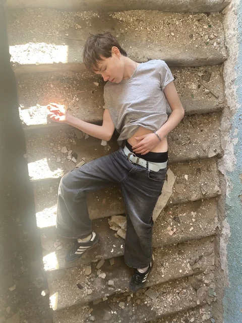A man sitting on a set of stairs with his hands on his hips.