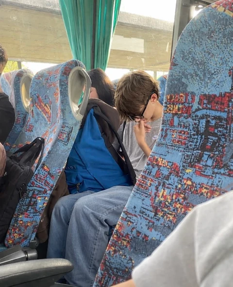 A group of people sitting on top of a bus.