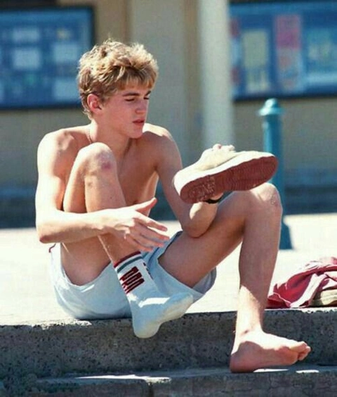 A young man sitting on the steps of a building.