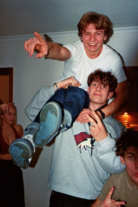 A group of young men standing on top of each other.