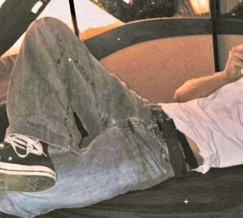 A pair of jeans and a pair of shoes are laying on a couch.