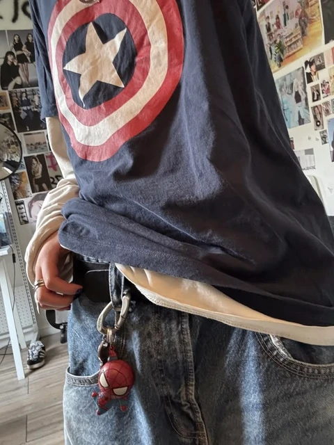 A man wearing a Captain America shirt with a spiderman on his chest.