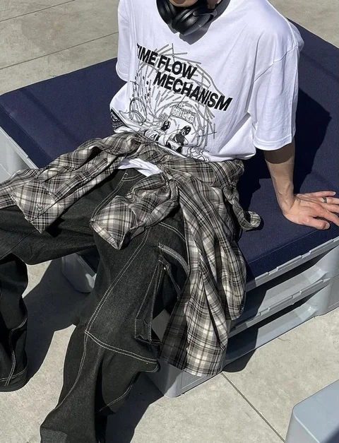A man wearing a white shirt with a black and white design on it.