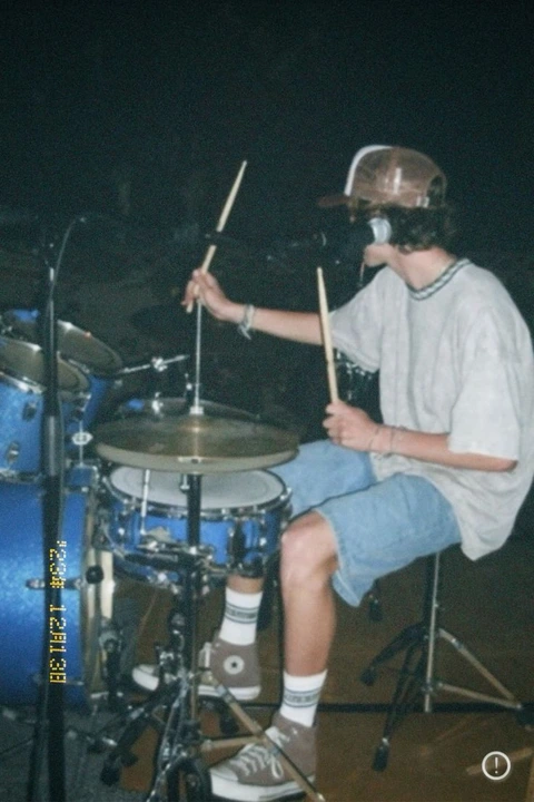 A man sitting on top of a drum set.