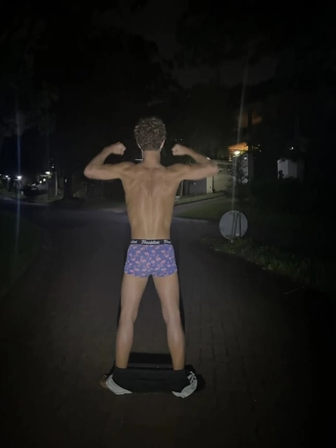 A man standing on top of a skateboard in the dark.
