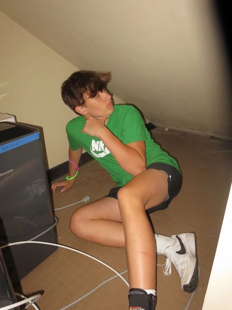 A young man sitting on the floor with his legs crossed.