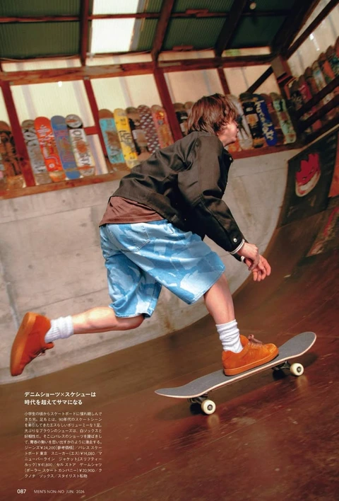 A man riding a skateboard on top of a wooden floor.