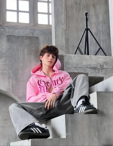 A young man sitting on the steps of a building.