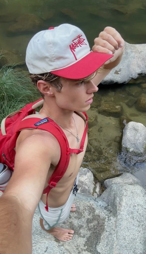 A man in a red backpack and a white hat.