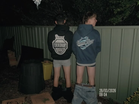 A group of young men standing next to each other in front of a fence.