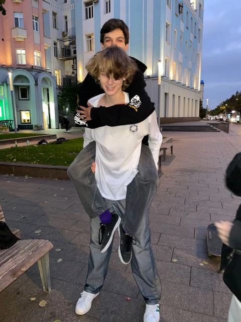 A man carrying a woman on his back in front of a building.