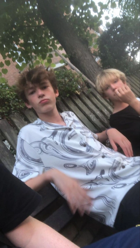 A group of young men sitting next to each other on a bench.