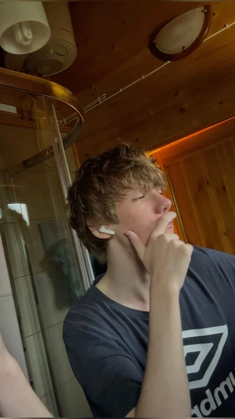 A young man is looking at himself in the mirror.