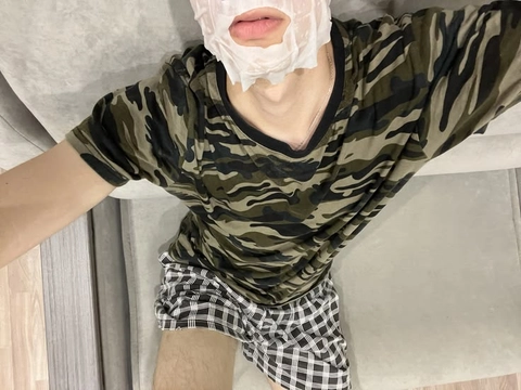A man wearing a camouflage shirt and plaid shorts.