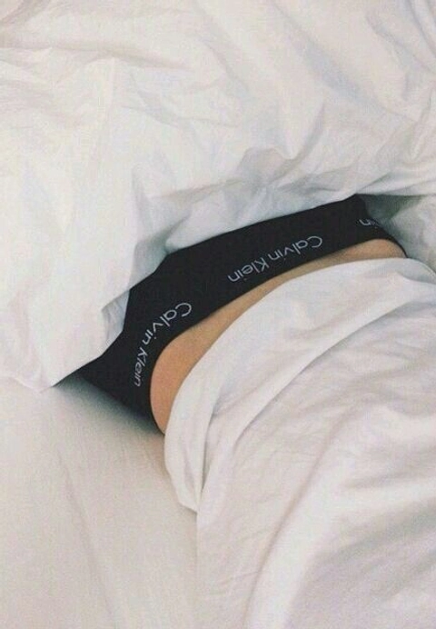 A close up of a person laying on a bed.