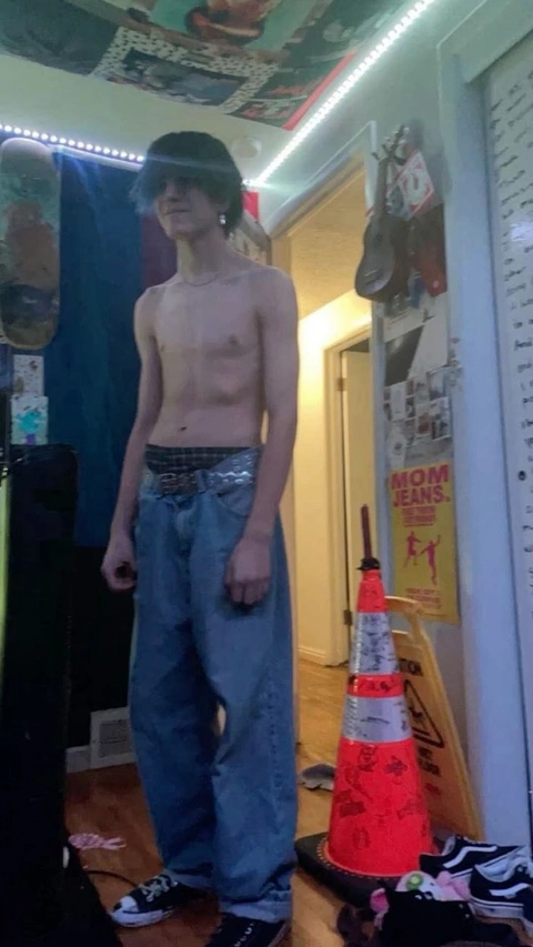 A shirtless man standing in front of a mirror.