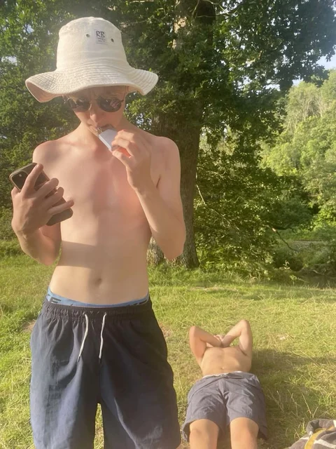 A man in a straw hat drinking from a bottle.