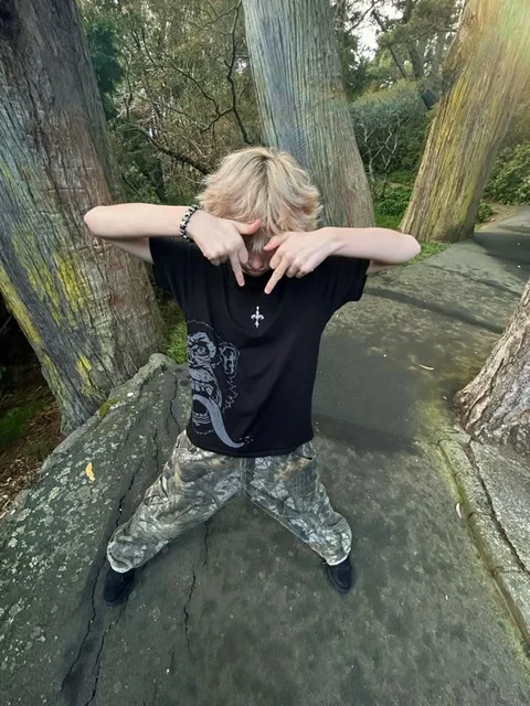 A man standing in front of a group of trees.