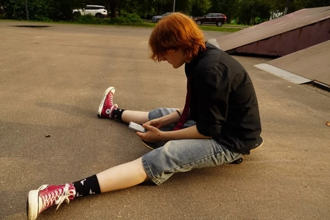 A man sitting on the ground with his legs crossed.