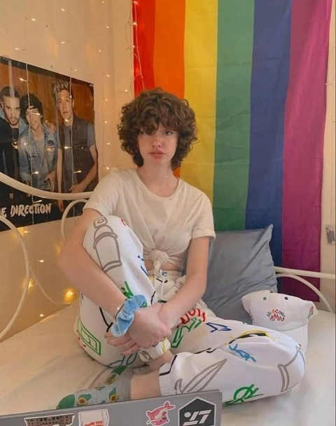 A woman sitting on top of a bed next to a mirror.