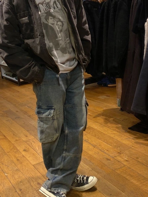 A man standing in front of a rack of clothes.