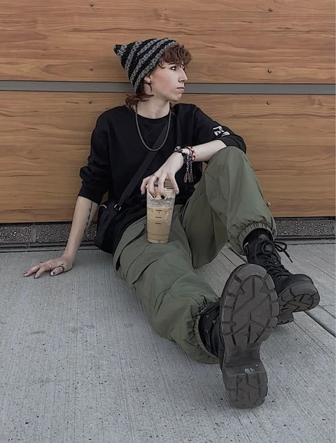 A man sitting on the ground with his feet up.