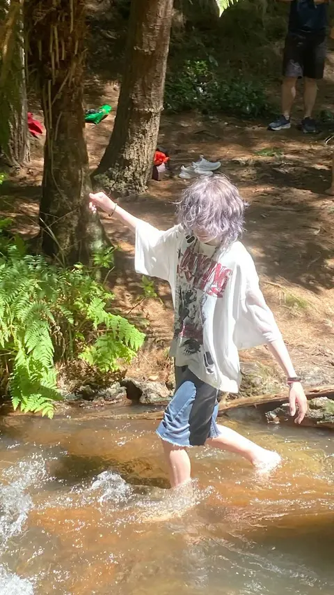 A person standing in the water with their arms outstretched.