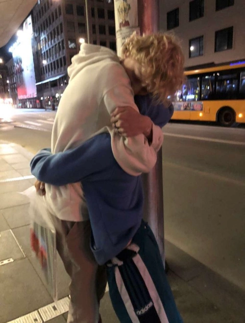 A couple of people hugging each other in the middle of a city.