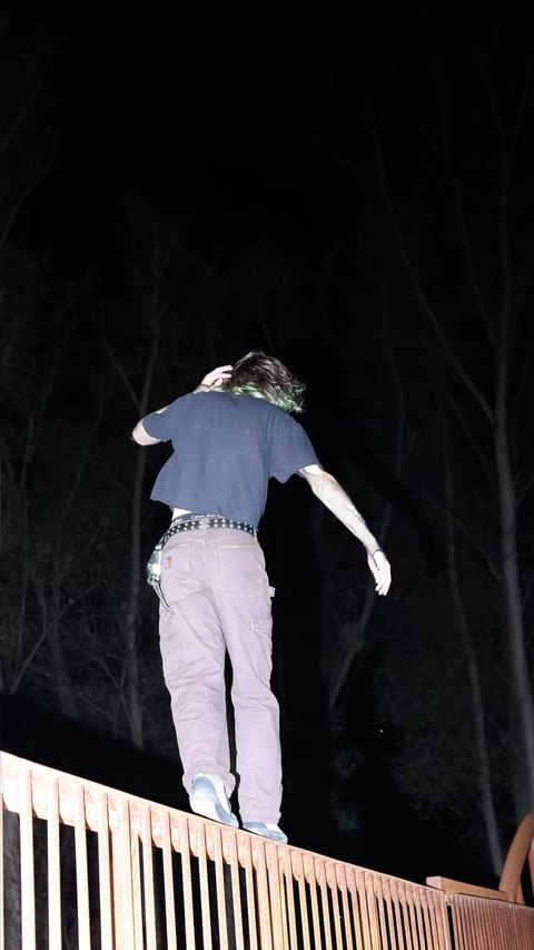 A man standing on top of a wooden fence.