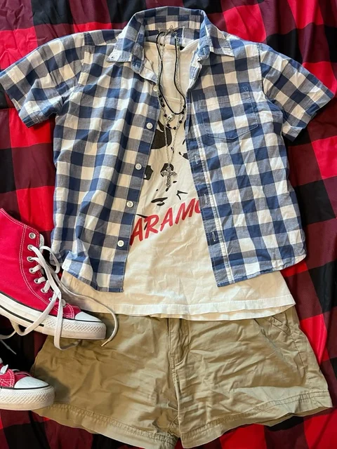 A pair of shorts, a shirt, and a pair of red converse sneakers.