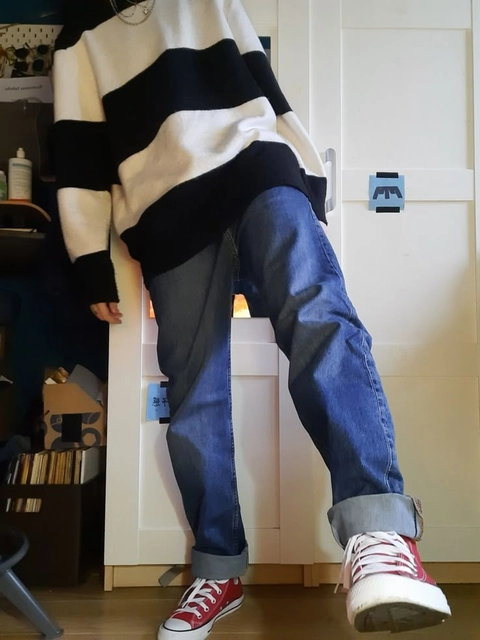 A mannequin wearing a black and white sweater and jeans.