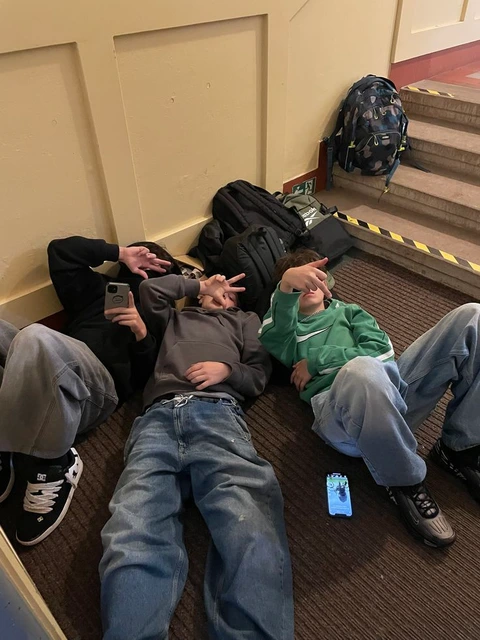 A group of people sitting on the steps of a building.