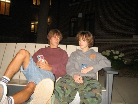 A group of young men sitting on top of a bench.