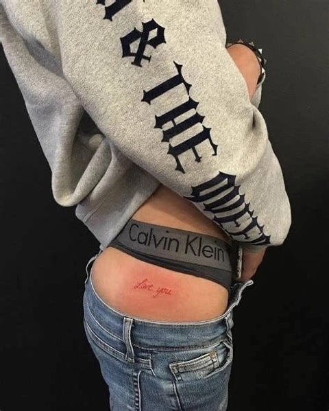 A woman with a tattoo on her stomach that says "I love you"