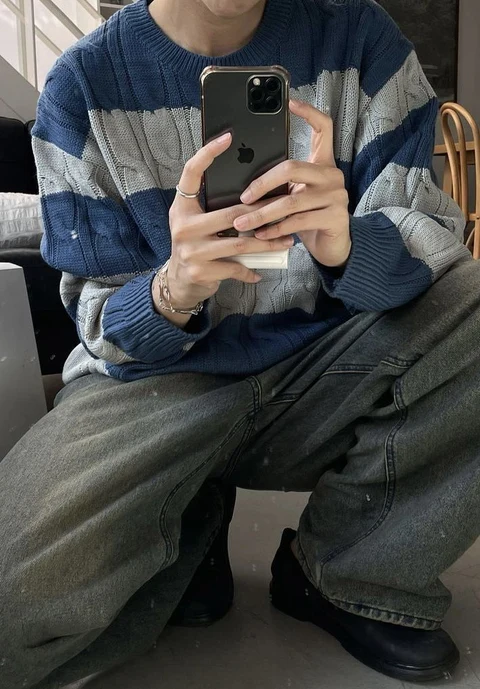 A man sitting on a couch holding a cell phone.