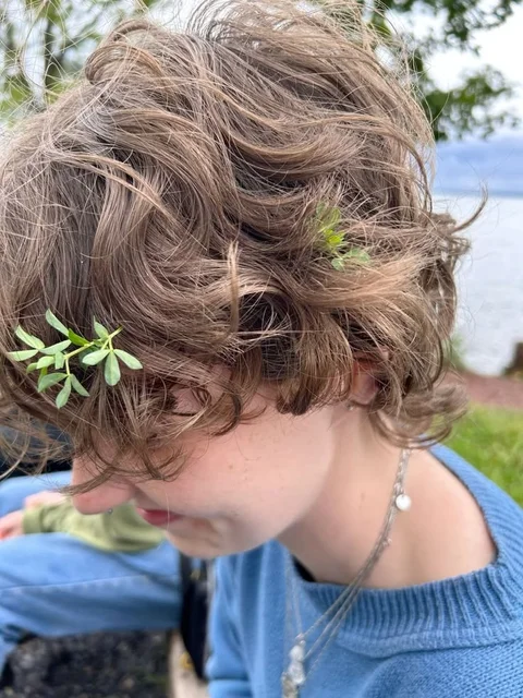 A woman with a bunch of leaves in her hair.