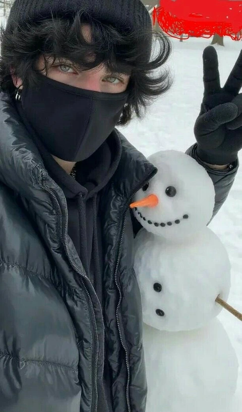 A man wearing a black mask and holding a snowman.