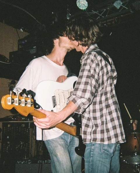 A group of young men playing guitars on a stage.